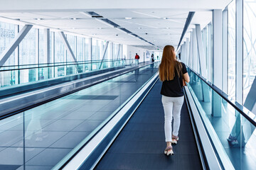 Young woman standing at the escalator in subway