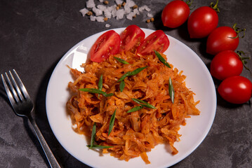 Stewed cabbage with onions and tomatoes is one of the most popular dishes. Homemade stewed cabbage with tomatoes and spices. View from above