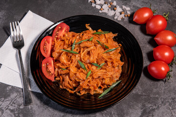 Stewed cabbage with onions and tomatoes is one of the most popular dishes. Homemade stewed cabbage with tomatoes and spices. View from above