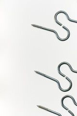 medium sized metal screw hooks on white, photographed with a macro lens, shallow depth of field 