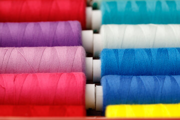 Fototapeta na wymiar Close up of colored thread coils, thread spools background