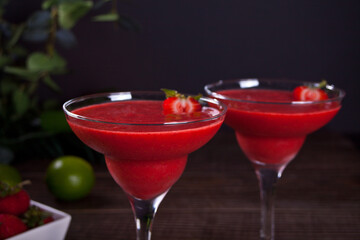 Cold strawberry margarita or daiquiri cocktail with lime and rum
