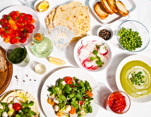 salad of fresh cherry tomatoes, mozzarella, basil and other greens on the dinner table with pita flat bread