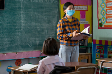 Asia female teacher wearing medical masks in the classroom,Social distancing and classroom safety during coronavirus epidemic,Safety and virus spread prevention,Social distancing.