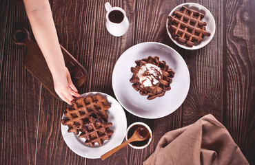 Homemade chocolate waffles with ice cream decorated chocolate syrup. Kids eating a waffles. Top view.