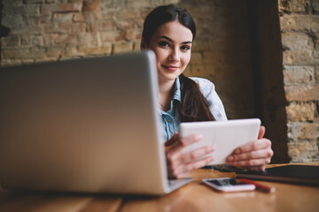 Smiling female browsing tablet during work