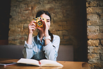 Focused female photographer with retro camera