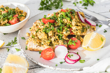 Tofu scramble with vegetables in white plate. Vegan Alternative food concept.