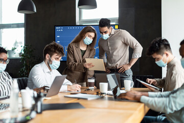 Colleagues having meeting in boardroom, businessman giving speech