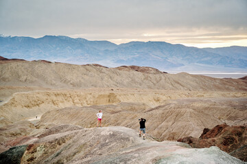 Fototapeta na wymiar A family is hiking and enjoying the views in Death Valley national park in California, USA. It’s March 2021, the weather is warm and sunny. The views are stunning and the sand desert is spectacular.