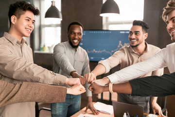 Portrait of smiling diverse business people giving fist bump