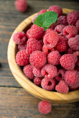 Fresh raspberry in wooden bowl. The berry is rich in vitamins.