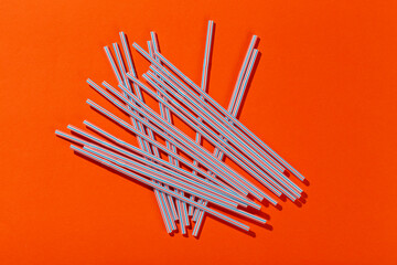 Colored tubules for juice and cocktails on orange background. Cocktail parties. Space for text.
