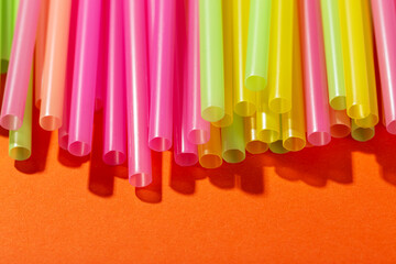 Colored tubules for juice and cocktails on orange background. Cocktail parties.