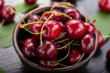 Freshly harvested cherries in a clay bowl from your home garden.