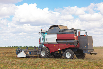 A large combine works in a wheat field