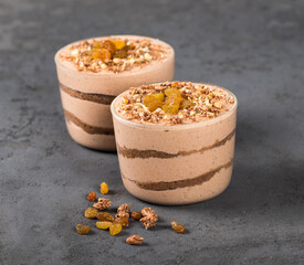 Italian dessert, tiramisu chocolate nut dried fruit in a glass jar on a dark gray background
