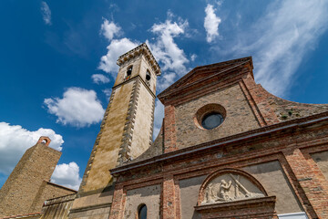 Fototapeta na wymiar The bell tower, part of the facade of the Santa Croce church and the tower of the Conti Guidi castle in the historic center of Vinci, Florence, Italy
