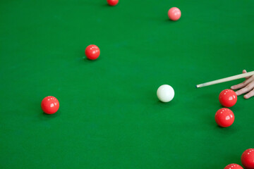 Red snooker balls are on the green table cloth.