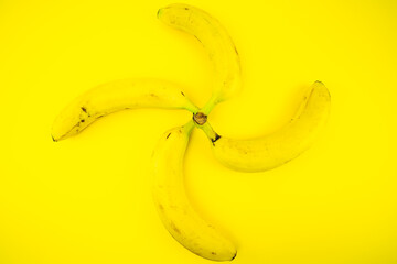 Quattro banane su sfondo giallo formano un elica