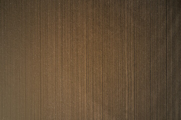 Brown ground, view to great heights. Plowed land aerial view. Cultivated soil top view. Preparing the soil for planting plants.