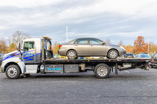 Sterling, USA - November 21, 2020: Car in tower tow vehicle truck due to fuel leak trouble damage safety in Virginia parking lot by auto repair shop