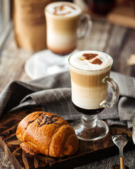 Glass mug of fresh coffee mocco and chocolate filled bun