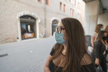 Ritratto di una ragazza sorridente con gli occhiali e la mascherina durante una giornata di svago in giro per la città di Ferrara