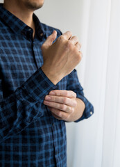 vitiligo man's hand fastens the sleeve of his shirt