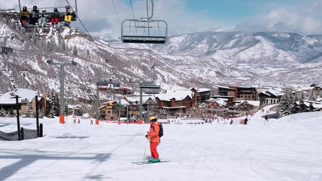 USA. Aspen. March 2021.Panoramic view on town in Colorado during winter season. People on skis and snowboards on the slopes of the ski resort. Ski elevator on snow mountain. 