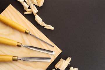 Set of gauges on wooden plank on black. Woodworking or carpentry flat lay. Top view. Copy space