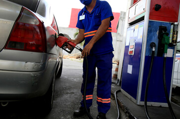 salvador, bahia, brazil - january 27, 2021: gas station attendant is seen during vehicle filling at...
