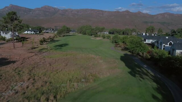 HD Drone tracking shot over fairway at Pearl Vally Golf Estate with Vast Mountain Range, Western cape, Cape Town, South Africa