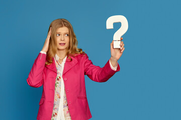 blonde woman in pink jacket holding question mark