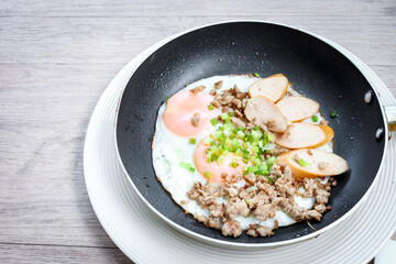 Pan-fried egg with toppings, hot breakfast in cooking served on table in morning.