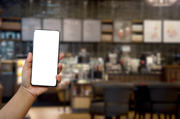 hand holding phone mockup image blank screen for advertising text in vintage cafe coffee shop background.