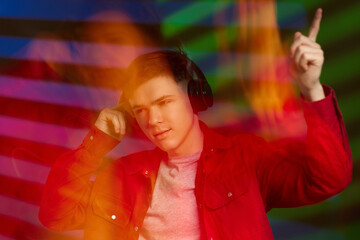 young man in red shirt with headphones listening to music