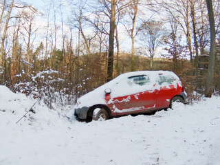 abandoned red car forest in snow crashed ditched hazard left behind vehicle