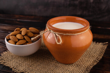 Milk in a rustic jug and almonds