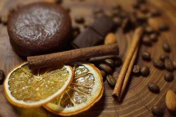 cinnamon sticks, dried orange, coffee and chocolate on a wooden surface
