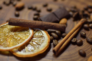 cinnamon sticks, dried orange, coffee and chocolate on a wooden surface