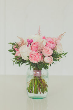 White and pink rose flowers in glass vase on white