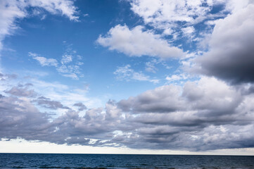Naklejka na ściany i meble Cloudy on blue sky over the sea