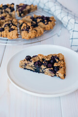 Freshly baked oat blueberry scones on white wooden background. Sweet food with natural ingredients. Vegan gluten free pastry.