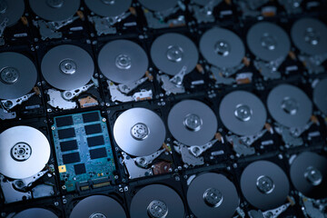 hi resolution photograph wallpaper of numbers of hard drives show inside metal disk and parts in pattern with focusing on the one of circuit of solid stage drive in cool blue tone light and shade