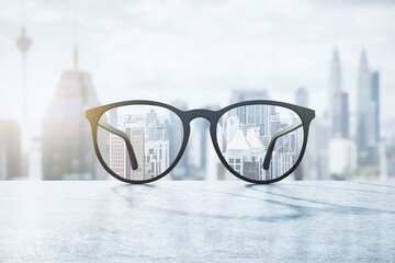 Clear view concept with eyeglasses with transparent lenses on marble surface and blurry city view...