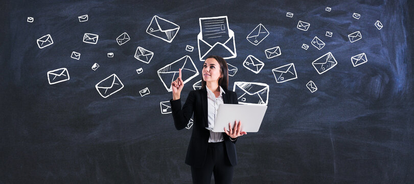 Mailing list and marketing concept with young woman with laptop on blackboard background with envelopes and letters.