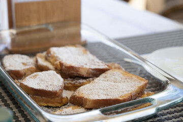 French toasts in glass tray at breakfast table. Homemade sweet dessert concept