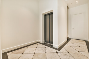 Interior of spacious hallway with metal elevator and tiled floor in contemporary residential building © Casa imágenes