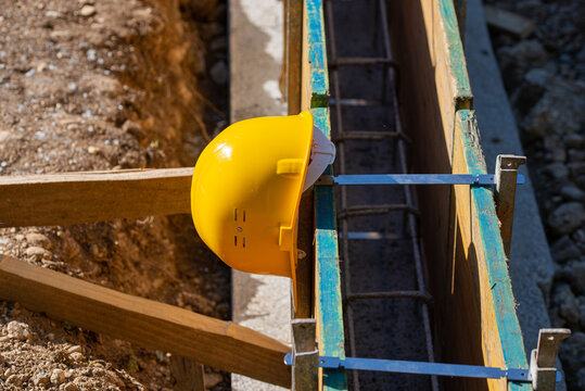 Yellow protective hardhat resting on a framework of wooden panels